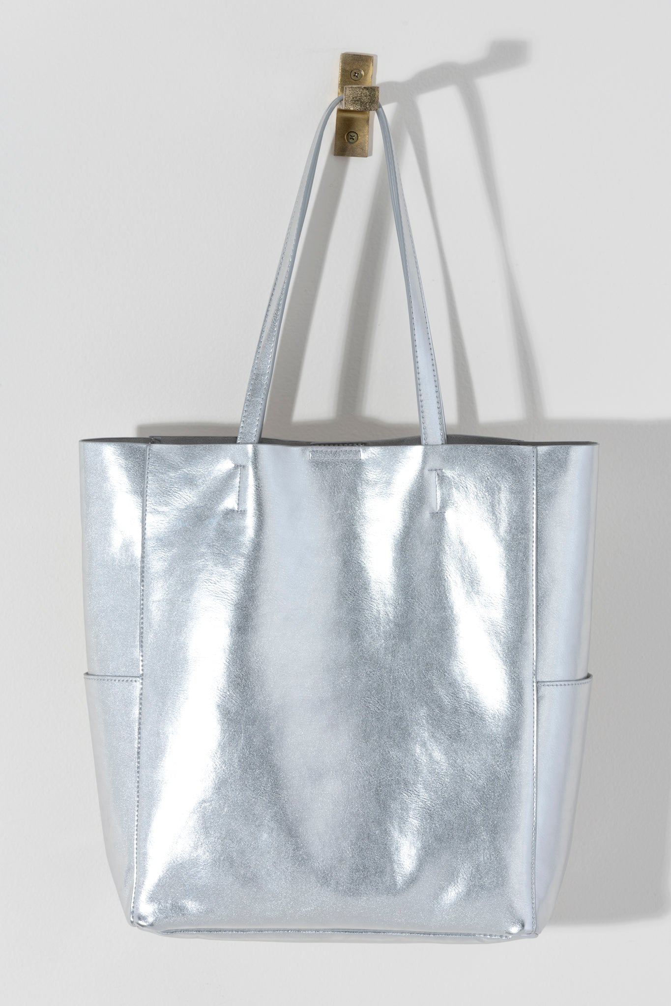 Make a statement this summer with Shiraleah's Maddie Tote. Made from metallic PU, this shiny accessory is sure to turn heads. With double shoulder straps and plenty of storage room, you won't need another bag to get you through this summer. Pair with other Shiraleah items to complete your look!