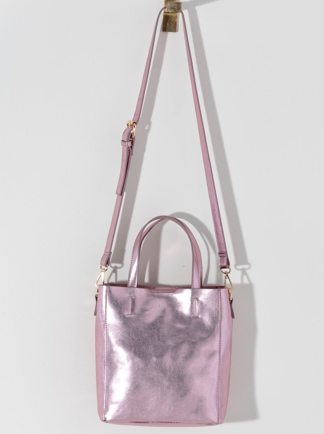 Make a statement this summer with Shiraleah's Maddie Mini Tote. Made from metallic PU, this shiny accessory is sure to turn heads. Add some versatility to your style by wearing with the detachable adjustable cross-body strap or carry with the standard double handles. Pair with other Shiraleah items to complete your look!
