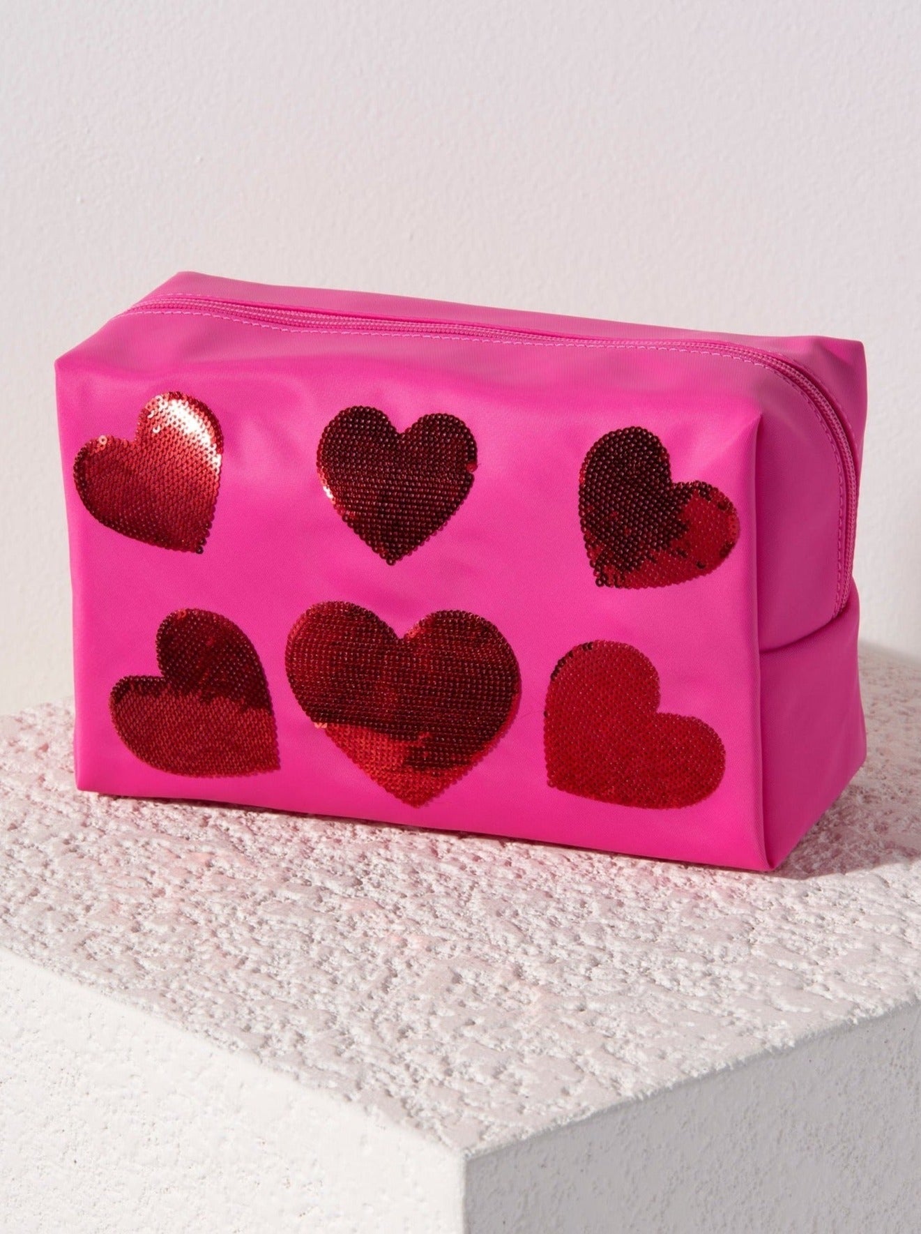 Carry all your odds and ends in style with Shiraleah's Cara Sequin Hearts Zip Pouch. Made of durable polyester in a vibrant pink color, this rectangular case is the perfect size to carry your makeup or toiletries on the go. The trendy sequin embroidery takes the shape of hearts, adding a little love wherever you take it. Pair with other items from Shiraleah to complete your look!